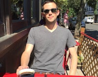 a man sitting at a table with a cup of coffee